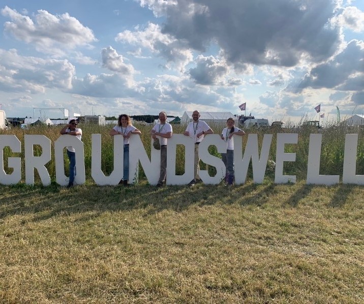 People standing next to large Groundswell sign.